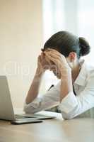 Confused businesswoman using laptop in conference room