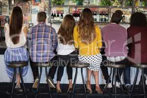 Rear view of friends sitting at restaurant