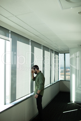 Worried business executive standing by window in office