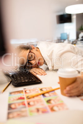Tired businesswoman napping on desk