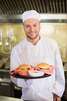Professional chef holding burgers in plate