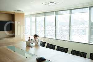 Cheerful businesswoman sitting at office