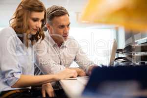 Business colleagues working together on laptop at desk