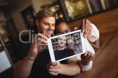 Happy couple taking selfie from digital tablet