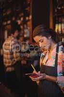 Waitress taking an order on notepad at counter
