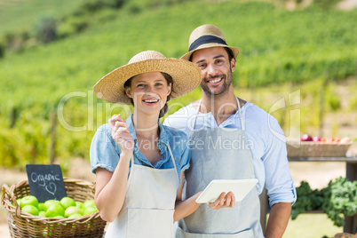 Portrait of happy couple holding digital tablet