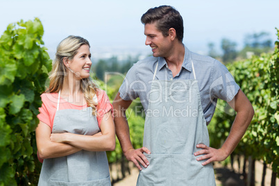 Smiling couple standing at vineyard
