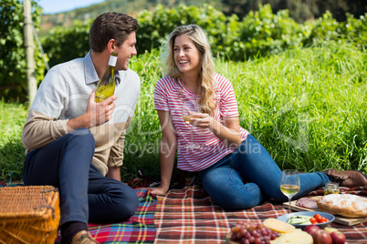 Happy couple holding winebottle and glass
