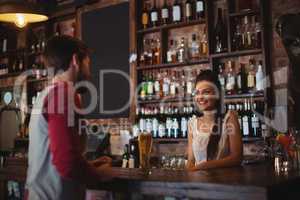 Female bar tender interacting with customer