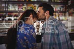 Affectionate man kissing woman at counter