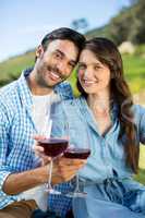 Portrait of young couple holding red wine glasses