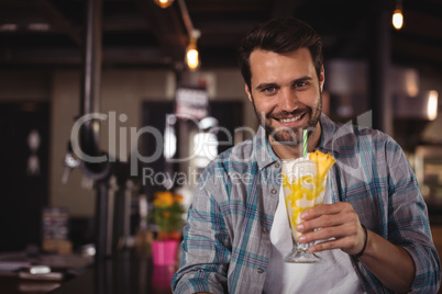 Portrait of happy man having milkshake