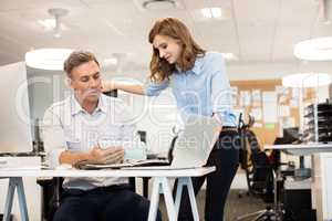 Businessman discussing with female colleague in office