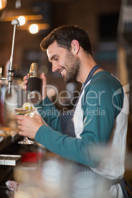 Side view of smiling bartender making drinks