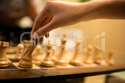 Cropped hand of businesswoman playing chess