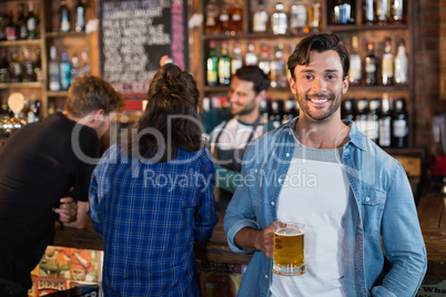 Portrait of smiling man holding beer mug i bar