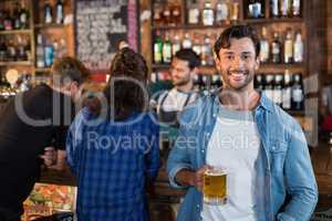 Portrait of smiling man holding beer mug i bar