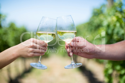 Cropped hands of couple toasting wineglasses