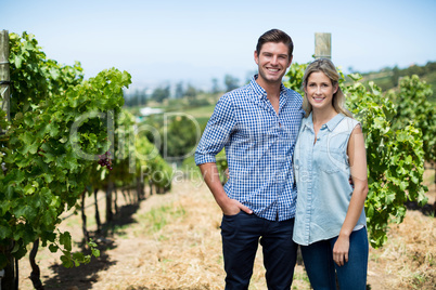 Portrait of young couple standing at vineyard