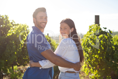 Portrait of smiling couple embracing at vineyard