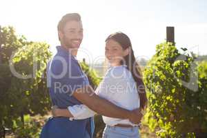 Portrait of smiling couple embracing at vineyard