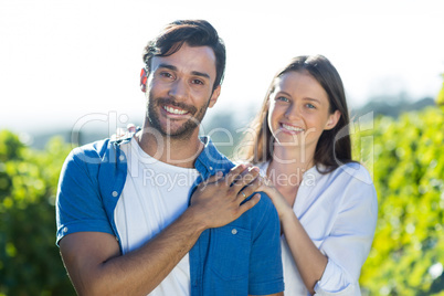 Portrait of happy young couple standing at vineyard