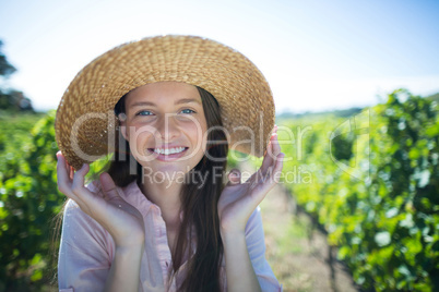 Portrait of beautiful young woman wearing hat on sunny day at vineyard