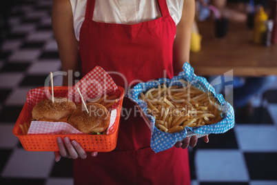 Waitress holding burger and french fries in tray