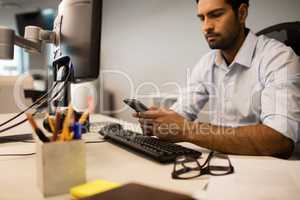Businessman using mobile phone while sitting at office