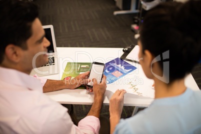 Business colleagues sitting together at desk