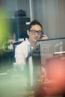 Businessman talking on phone while working in office