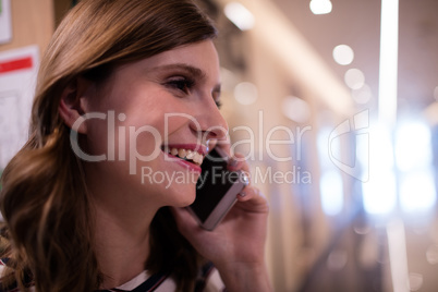 Happy businesswoman talking on mobile phone at office