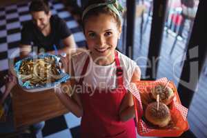 Waitress holding burger and french fries in tray