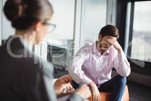 Unhappy man consulting counselor