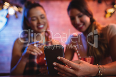 Two young women using mobile phone