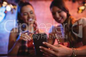 Two young women using mobile phone