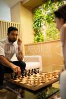 Businessman playing chess with female colleague