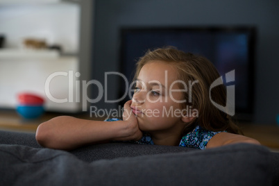 Upset girl sitting on sofa in living room