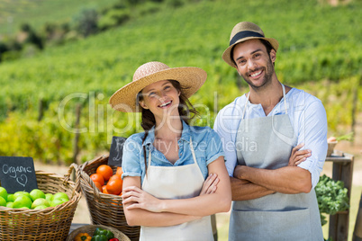 Portrait of happy couple with arms crossed at farm