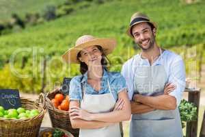 Portrait of happy couple with arms crossed at farm