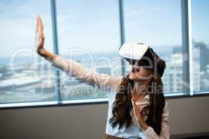Cheerful businesswoman gesturing while using virtual reality glasses