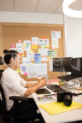 Designer using mobile phone in creative office