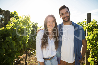 Portrait of smiling couple standing at vineyard