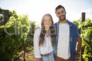 Portrait of smiling couple standing at vineyard