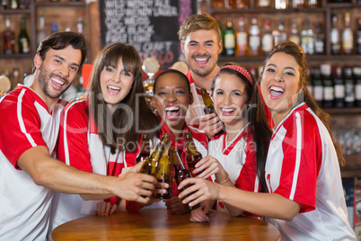 Friends toasting beer bottles in pub