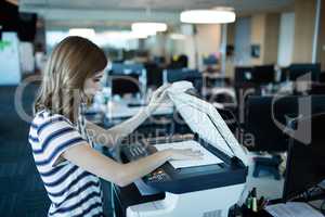 Businesswoman using copy machine in office