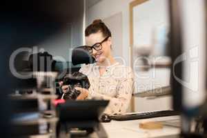 Smiling female photographer using camera at creative office