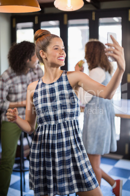 Young woman taking selfie in restaurant