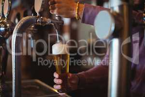 Close-up of bar tender filling beer from bar pump