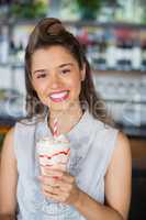 Young woman drinking smoothie at restaurant